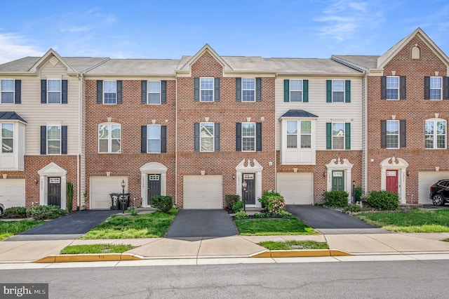 townhome / multi-family property with brick siding, driveway, and a garage