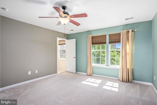 empty room with visible vents, a ceiling fan, baseboards, and carpet floors
