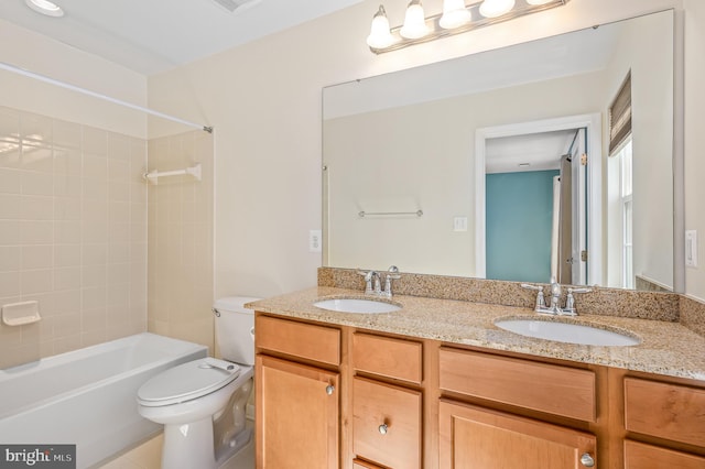 full bath featuring double vanity, a sink, bathing tub / shower combination, and toilet