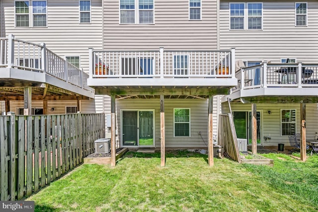 back of property featuring a lawn, cooling unit, a wooden deck, and a fenced backyard