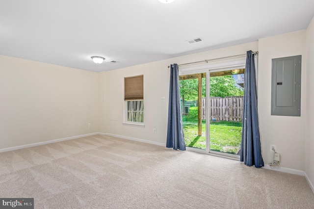 unfurnished room with visible vents, baseboards, carpet floors, and electric panel