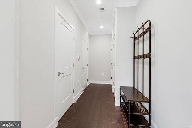 corridor with visible vents, baseboards, dark wood finished floors, recessed lighting, and ornamental molding