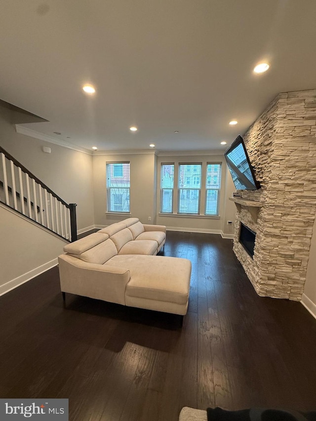 unfurnished living room featuring baseboards, stairs, ornamental molding, a fireplace, and dark wood-style floors