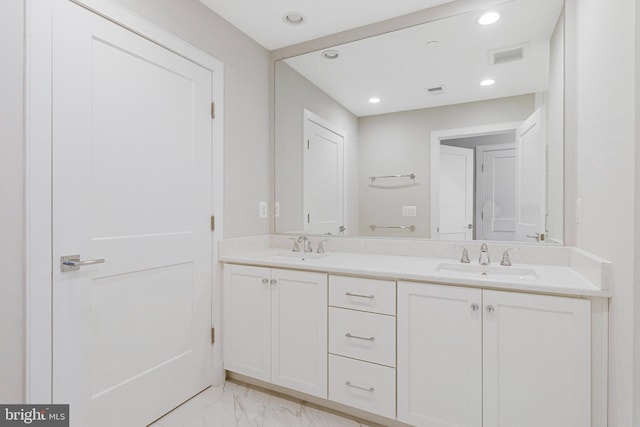 full bath featuring double vanity, visible vents, marble finish floor, and a sink