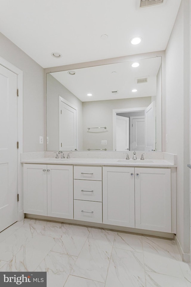 bathroom featuring a sink, visible vents, marble finish floor, and double vanity