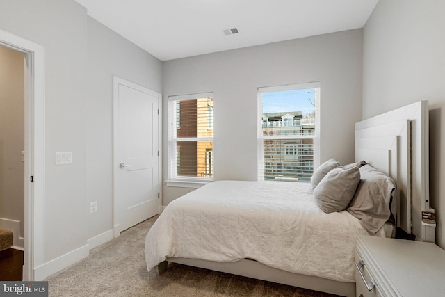 carpeted bedroom with visible vents and baseboards