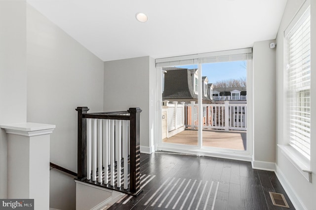 interior space featuring visible vents, dark wood-type flooring, and baseboards