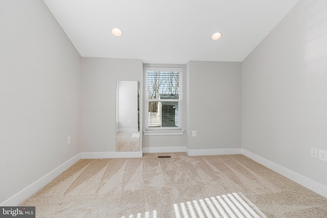 carpeted spare room featuring recessed lighting, visible vents, and baseboards