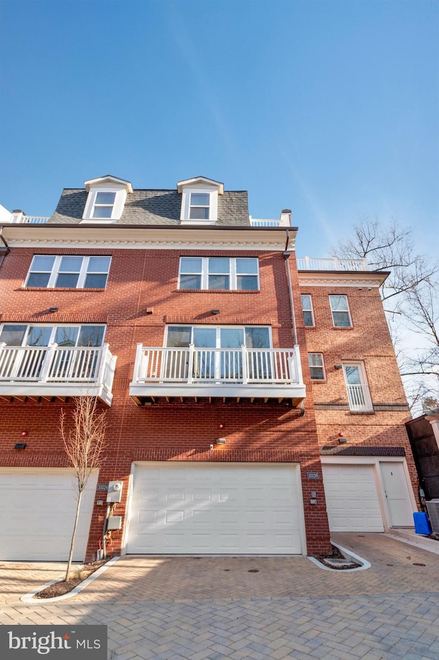 view of front of home featuring brick siding, driveway, and an attached garage