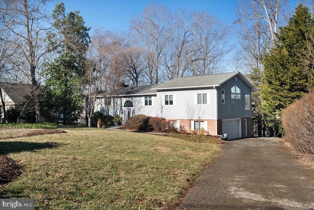 view of front of house with a garage, driveway, brick siding, and a front yard