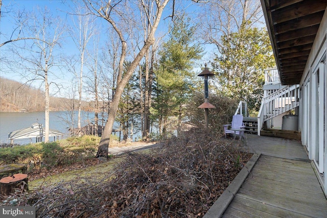 view of yard featuring a water view and stairs