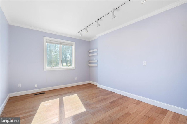 unfurnished room featuring light wood finished floors, visible vents, and baseboards