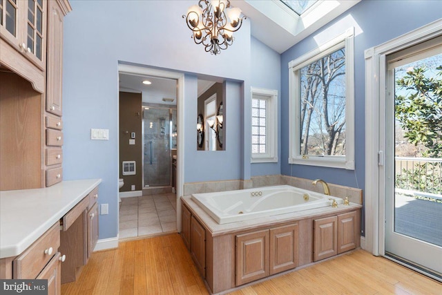 full bath with toilet, a stall shower, a jetted tub, and wood finished floors