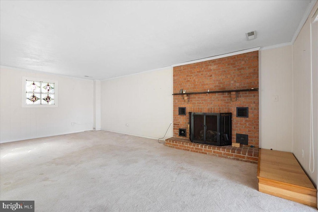 unfurnished living room featuring a brick fireplace, carpet, and ornamental molding