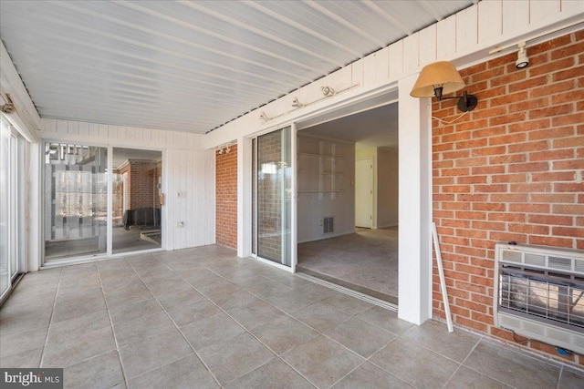 view of patio / terrace featuring heating unit and visible vents