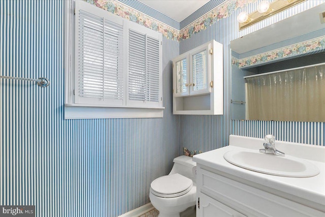 bathroom featuring toilet, a shower with shower curtain, vanity, and wallpapered walls