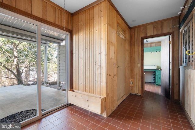 doorway to outside featuring tile patterned flooring and wooden walls