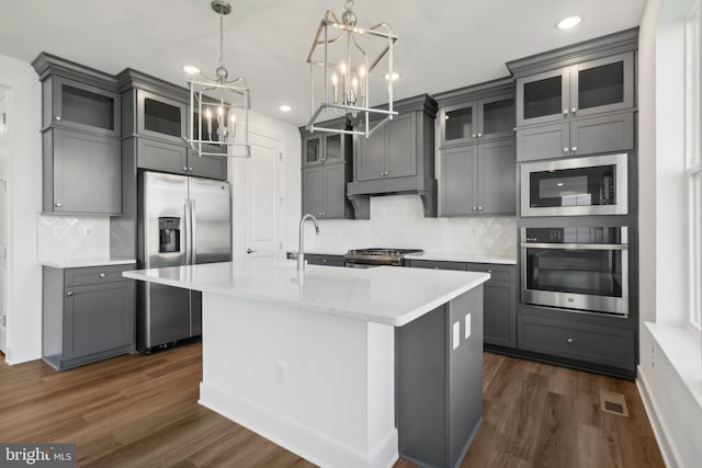 kitchen with stainless steel appliances, dark wood finished floors, gray cabinets, and light countertops