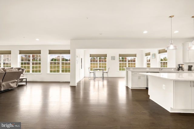 kitchen featuring recessed lighting, white cabinetry, open floor plan, dark wood finished floors, and decorative light fixtures