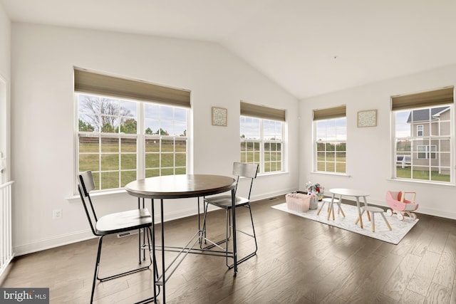 dining area featuring lofted ceiling, baseboards, and wood finished floors