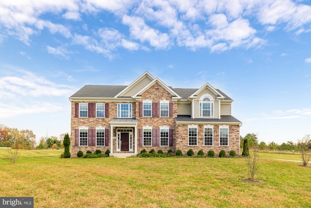 view of front of house with stone siding and a front lawn