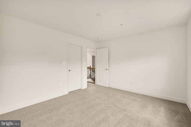 empty room featuring carpet and baseboards