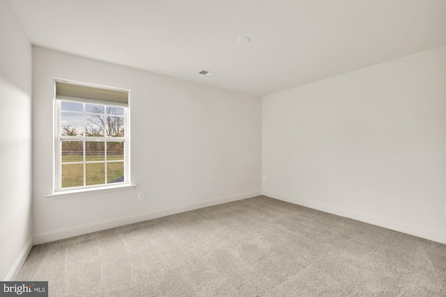 carpeted spare room with visible vents and baseboards