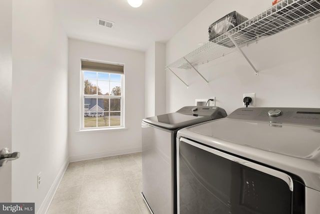 washroom with laundry area, visible vents, independent washer and dryer, and baseboards