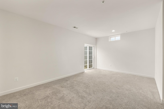 empty room with recessed lighting, baseboards, visible vents, and light colored carpet