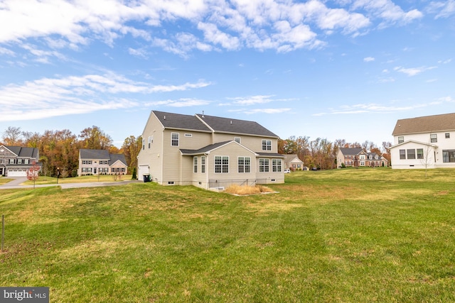 rear view of house featuring a residential view and a yard