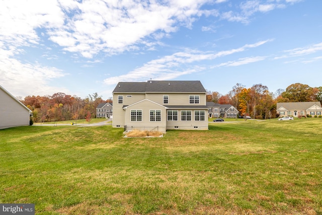 rear view of house with crawl space and a lawn