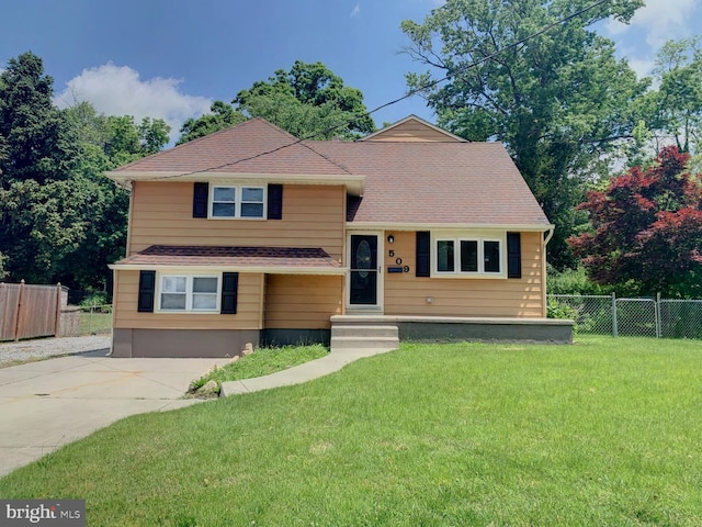 split level home featuring fence and a front lawn