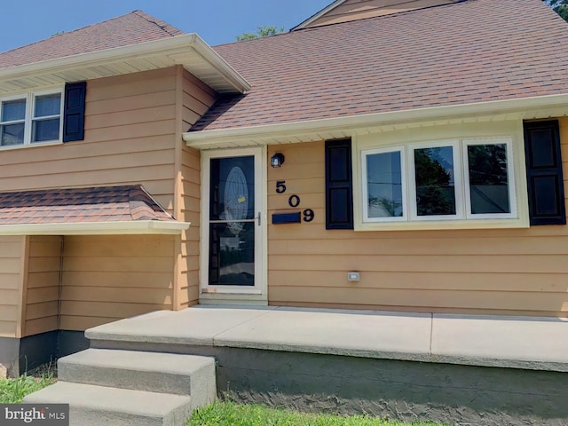 doorway to property featuring a shingled roof