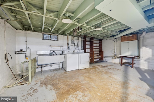 unfinished below grade area with washer and clothes dryer and a sink