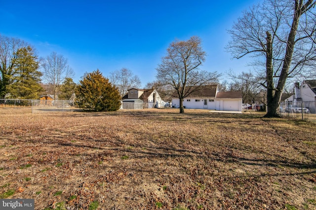 view of yard featuring an attached garage and fence