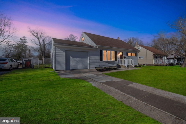 view of front of property with driveway, an attached garage, a yard, and fence