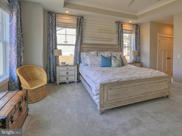 carpeted bedroom with recessed lighting, a raised ceiling, and crown molding