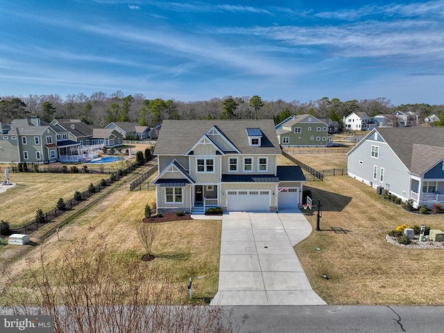 view of front of house with board and batten siding, an attached garage, fence, and a residential view