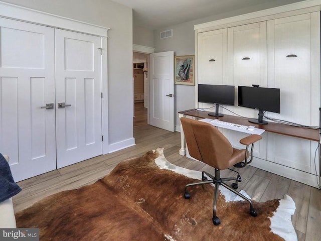 office with baseboards, visible vents, and light wood-style floors