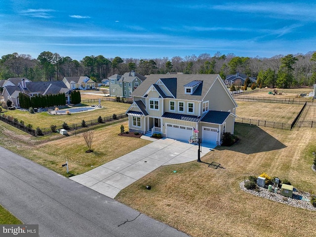 view of front of property with board and batten siding, fence, a garage, driveway, and a front lawn