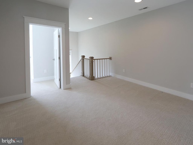 spare room with light colored carpet, recessed lighting, visible vents, and baseboards