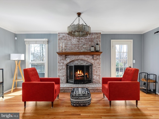 living area with a fireplace, plenty of natural light, wood finished floors, and ornamental molding