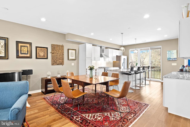 dining area featuring recessed lighting, light wood-type flooring, and baseboards