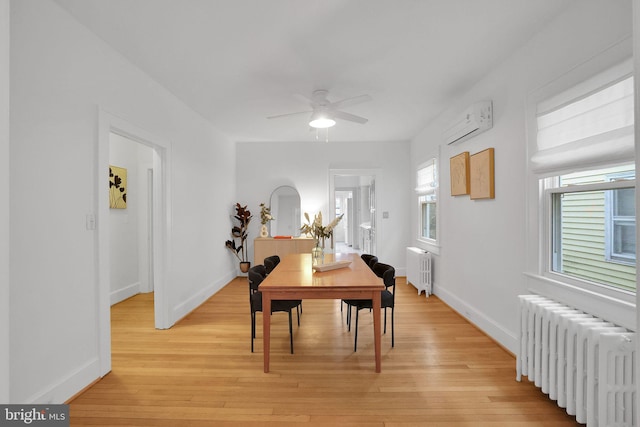 dining space featuring a wall unit AC, light wood-style flooring, and radiator