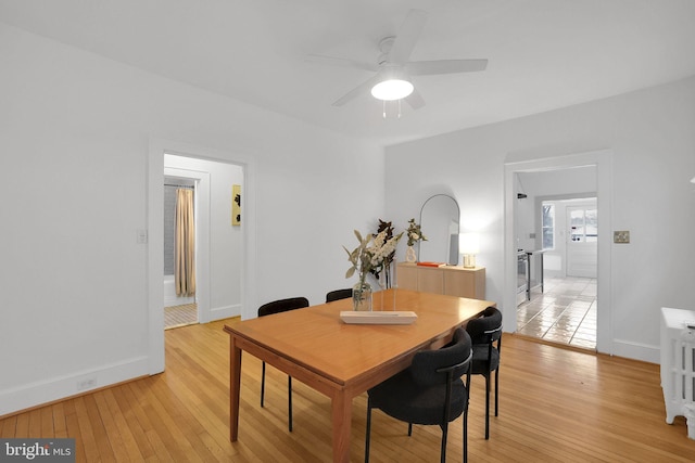 dining room with light wood-style floors, ceiling fan, and baseboards