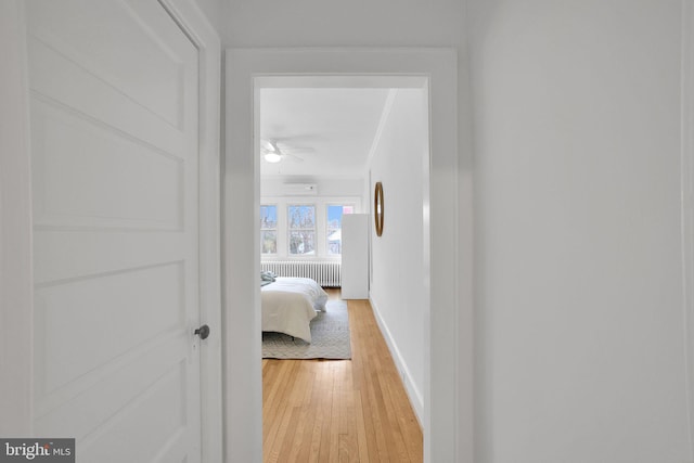 corridor featuring baseboards and light wood finished floors