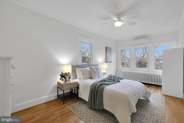 bedroom with light wood finished floors, radiator heating unit, ornamental molding, and baseboards