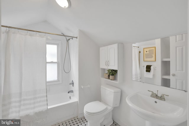 bathroom featuring lofted ceiling, shower / bath combination with curtain, toilet, and a sink