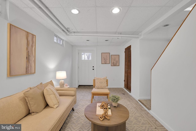 living area featuring recessed lighting, a paneled ceiling, and baseboards