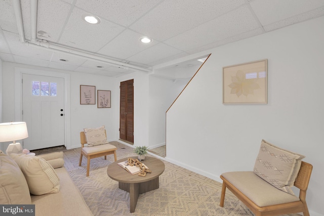 living room with recessed lighting, a drop ceiling, and baseboards